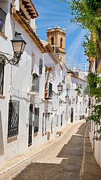 Typical street of Altea old town with white houses in Spain. Beautiful village with cobblestoned narrow streets, popular