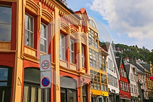 Typical street in Bergen, historic architecture, colourful wooden buildings and Floyan mountain in the background on a summer day.