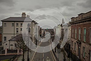 Typical street in centre of Derry or Londonderry, viewed from the bridge above it. Cloudy day in Derry and a row of houses on each