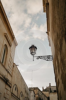 A typical street lamp with a crown on a wall in Lecce with clear blue skies, Italy photo