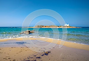 Typical summer image of an amazing pictorial view of a sandy beach and an old white church in a small isl