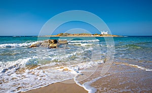 Typical summer image of an amazing pictorial view of a sandy beach and an old white church in a small isl photo