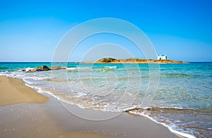 Typical summer image of an amazing pictorial view of a sandy beach and an old white church in a small isl photo