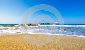 Typical summer image of an amazing pictorial view of a sandy beach and an old white church in a small isl photo