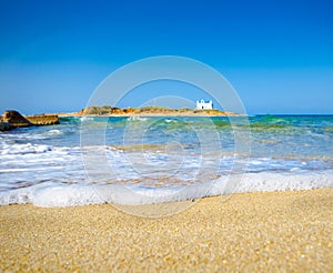 Typical summer image of an amazing pictorial view of a sandy beach and an old white church in a small isl photo