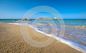 Typical summer image of an amazing pictorial view of a sandy beach and an old white church in a small isl photo