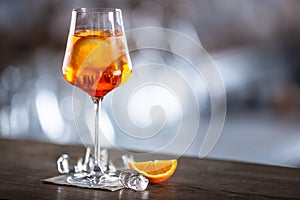 Typical summer sekt drink aperol spritz served in wine glass with aperol, prosecco, soda and a slice of orange