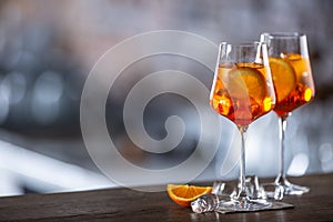 Typical summer sekt drink aperol spritz served in wine glass with aperol, prosecco, soda and a slice of orange