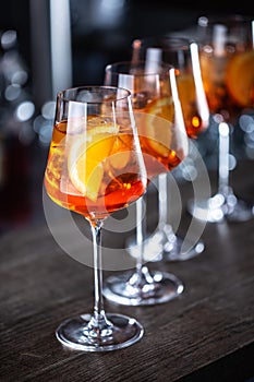 Typical summer sekt drink aperol spritz served in wine glasses with aperol, prosecco, soda and a slice of orange