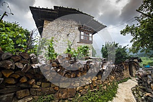 Traditional Bhutanese farmhouse , with firewood on the fence wall , Ura Valley , Bhutan photo
