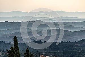 Typical Tuscan landscape with hills and cypresses in the very early morning near Montaione