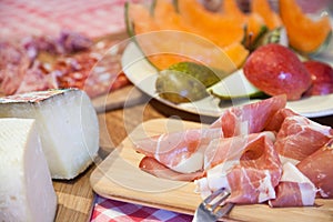 Typical Tuscany cuisine with prosciutto, cheese and fruit photo