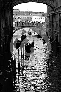 typical venetian gondoliere and a bridge crowded with tourists