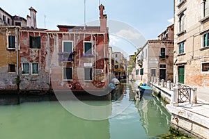 Typical view of boats and gondolas under on the canal of Venice.