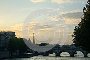 Typical view of Paris with Pont-Neuf and Seine river at sunset. Eiffel Tower can be seen in the background