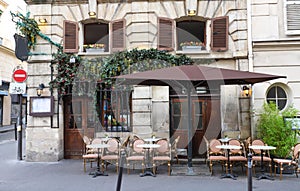 Typical view of the Parisian street with tables of cafe in Paris, France. Architecture and landmark of Paris.