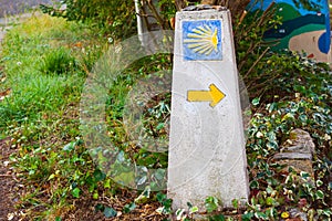 Typical Way of Saint James Camino de Santiago milestone with a yellow shell and yellow arrow