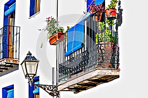 White facades with flowers on the street balconies in PeÃ±Ã­scola Castle, CastellÃ³n, Valencian Community, Spain photo