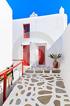 Typical white Greek house with red doors and window in beautiful Mykonos town, Cyclades islands, Greece