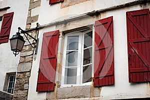 Typical white houses with red colored window shutters