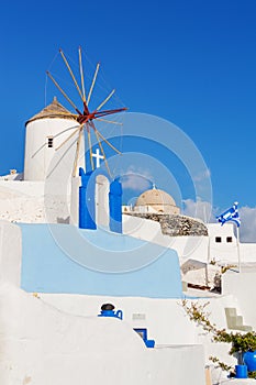 Typical white windmill on street of Oia village