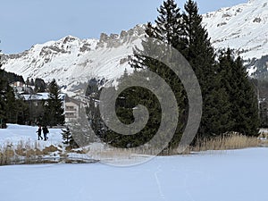 A typical winter idyll on the frozen and snow-covered alpine lake Heidsee (Igl Lai) in the winter resort Lenzerheide