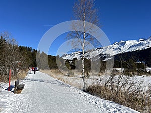 A typical winter idyll on the frozen and snow-covered alpine lake Heidsee (Igl Lai) in the winter resort Lenzerheide