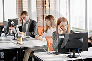 typical working day. young business people sitting in modern office and using computer