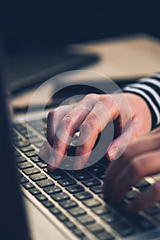 Typing hands and laptop computer in office