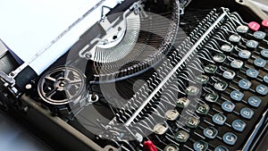 Typing on the keyboard of an old, retro typewriter.