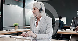 Typing, talking and a mature woman in a call center for telemarketing, support or consulting. Happy, contact us and a