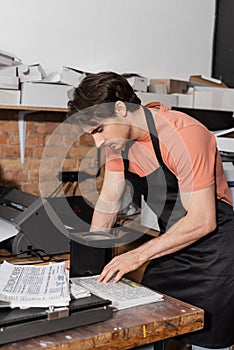 typographer in apron checking quality of