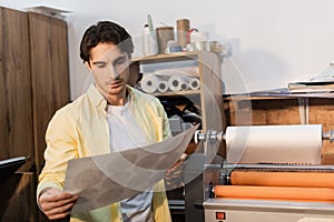 typographer looking at printed paper near