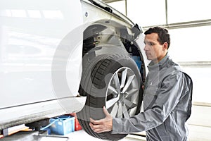 Tyre change in a workshop - assembler in working clothes