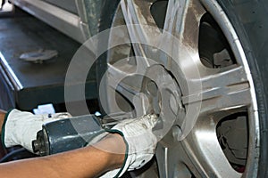 Tyre repairer fixing a wheel using an impact wrench