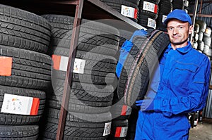 Tyre replacement. mechanic holding tire in store warehouse