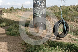 Tyre rope swing on industrial waste ground