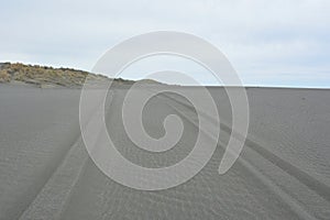 tyre tracks at grey beach sand