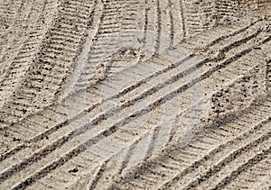 Tyre tracks on sandy road with blur effect.