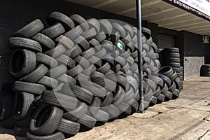 Tyres stacked herringbone outside for recycling
