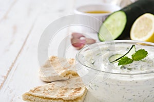 Tzatziki in bowl on a white wooden table
