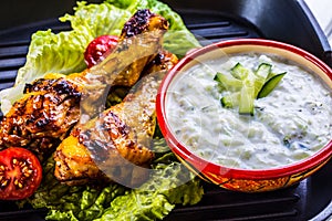 Tzatziki sauce. Tzatziki dressing. Tzatziki dressing with grilled chicken legs and fresh vegetable,lettuce leaf and cherry