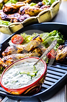 Tzatziki sauce. Tzatziki dressing. Tzatziki dressing with grilled chicken legs and fresh vegetable,lettuce leaf and cherry