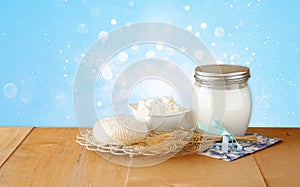 Tzfatit cheese , cottage and milk on wooden table over blue glitter background. jewish holiday Shavuot concept