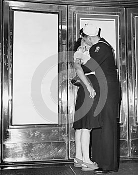 U.S. sailor and his girlfriend celebrate news of the end of war with Japan in front of the Trans-Lux Theatre in New York's Time Sq