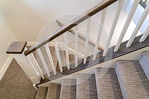 U shaped indoor staircase of home with treads and landing covered with carpet