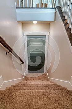 U shaped staircase that leads to the basement door from main floor of home