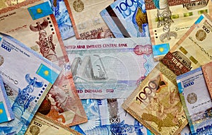 UAE banknotes on top of Kazakhstan national currency, top view of mixed tenge banknotes. Kz paper money. Tenge and dirham exchange