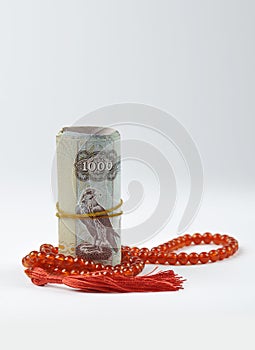 UAE dirham currency notes placed with Islamic rosary.