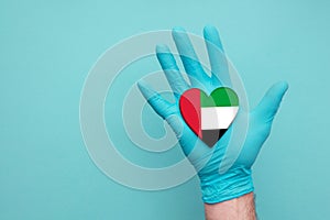 UAE medical health heart. Nurse hand holding country heart flag